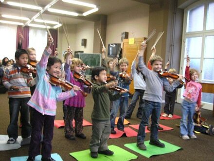 Eine Gruppe Kinder spilet Geigen